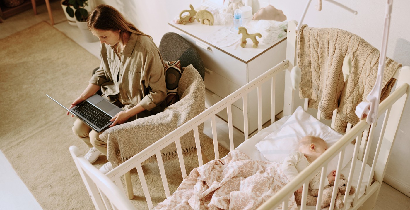 Jeune maman préparant ses achats bébé en ligne pendant que son enfant dort