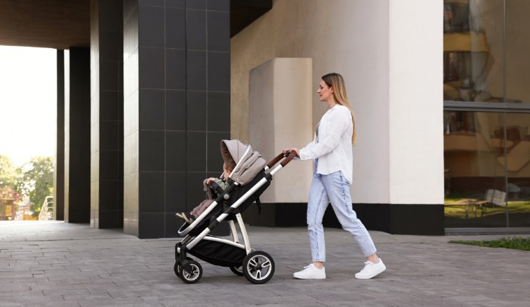 Parent promenant un bébé dans une poussette en ville