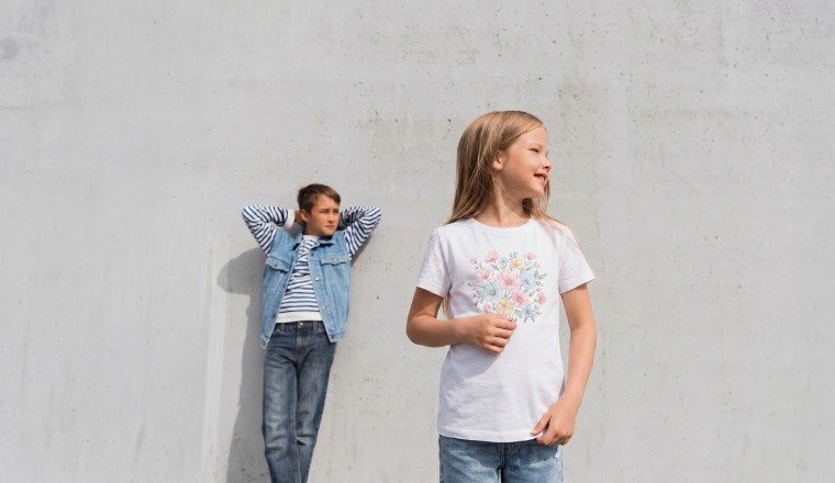 Deux enfants portant des vêtements décontractés devant un mur clair.