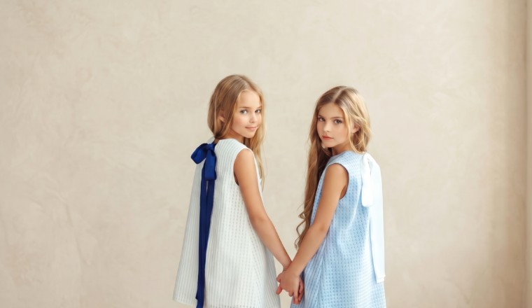 Deux fillettes portant des robes élégantes bleu ciel et blanc dans un décor lumineux