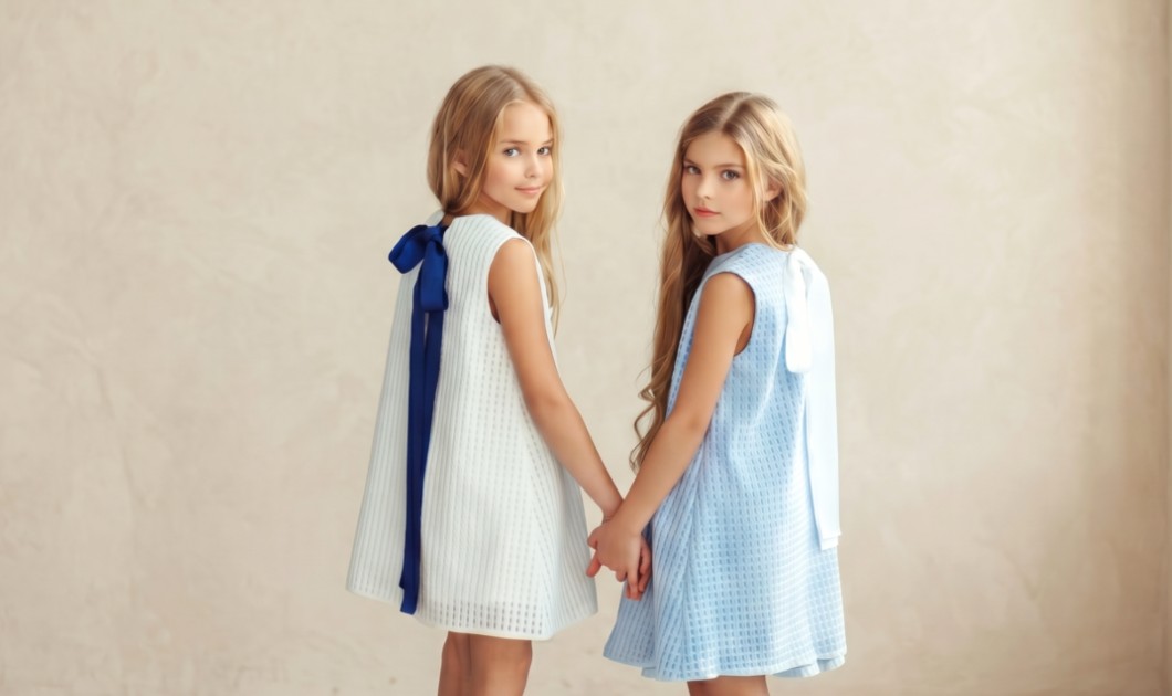 Deux fillettes portant des robes élégantes bleu ciel et blanc dans un décor lumineux