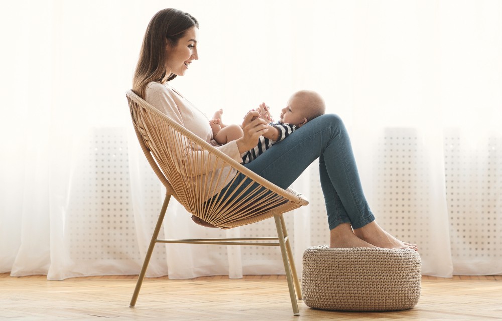maman assise dans un fauteuil avec son bébé dans une ambiance douce