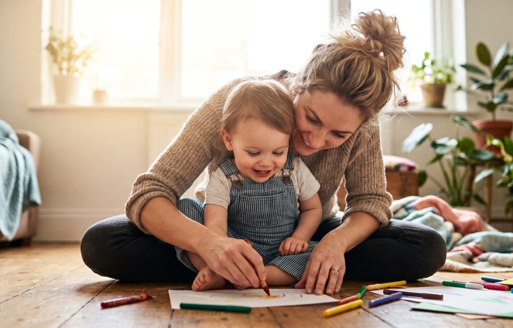 Maman et jeune enfant dessinant ensemble à la maison