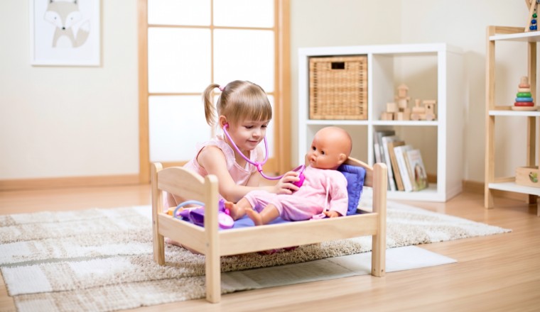 Enfant prenant soin de sa poupée dans une chambre aux tons doux